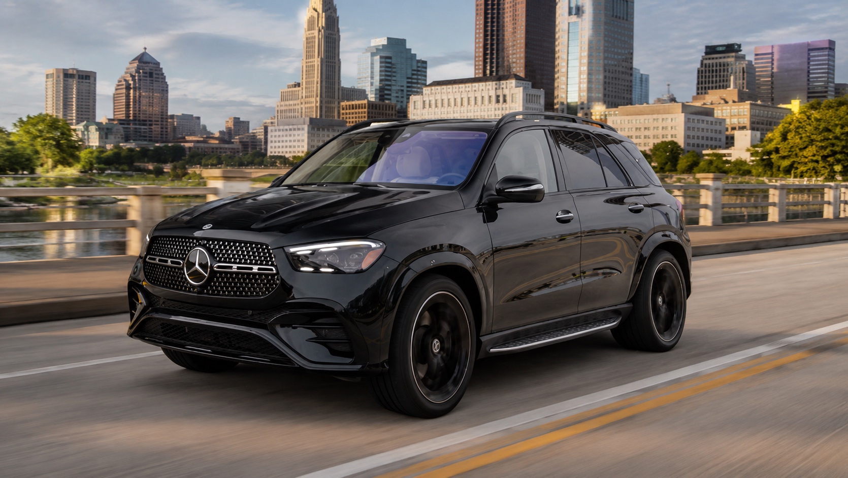 Black Mercedes SUV crossing a bridge with the Columbus skyline behind